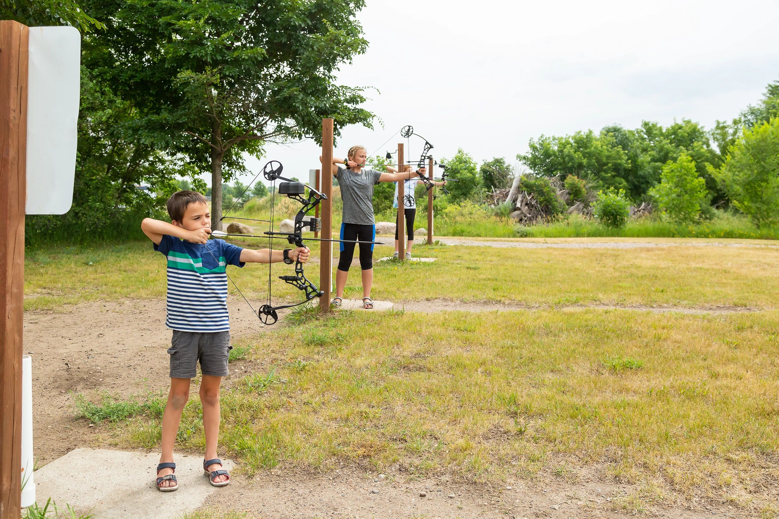 Students practicing archery together outdoors
